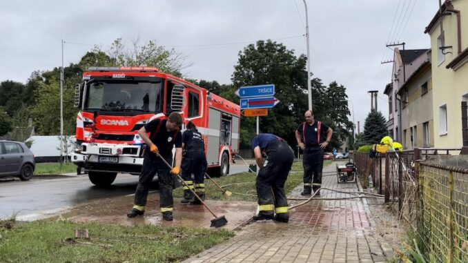 Úklid zaplavené ulice po bouřce