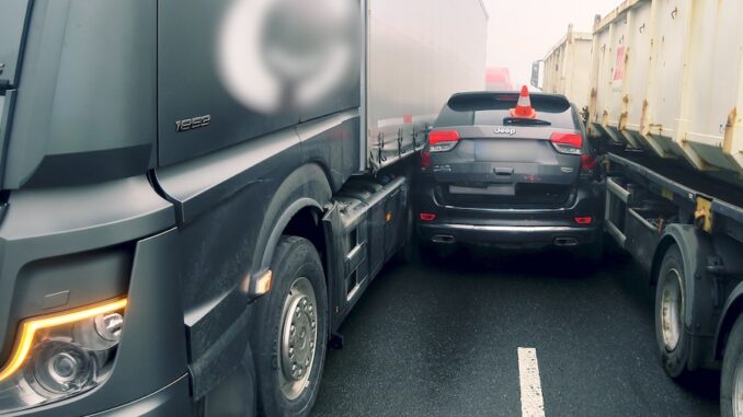 Auto zaseklé mezi náklaďáky